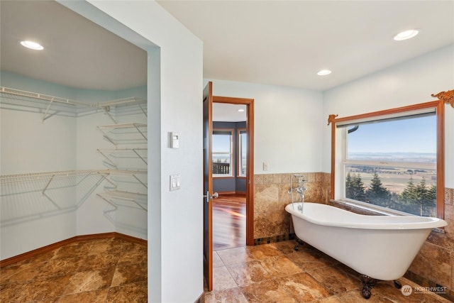 bathroom with a bathtub and tile walls