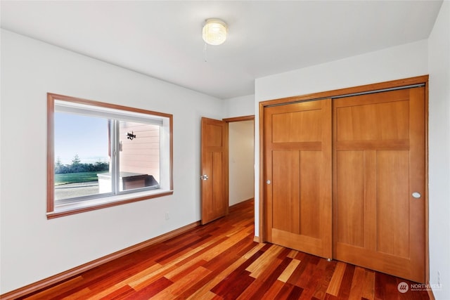 unfurnished bedroom featuring dark hardwood / wood-style flooring and a closet