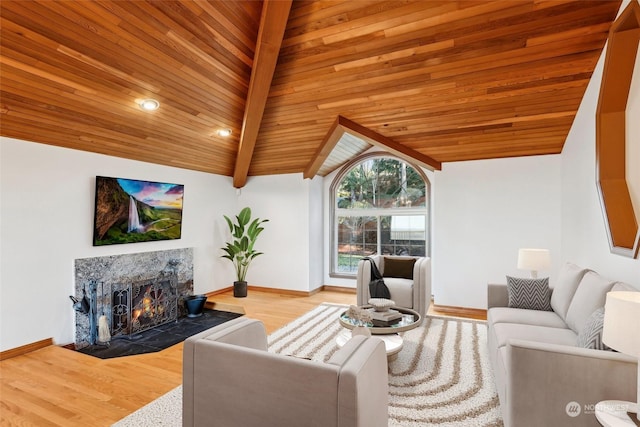 living room featuring wood ceiling, a fireplace, light hardwood / wood-style flooring, and vaulted ceiling with beams