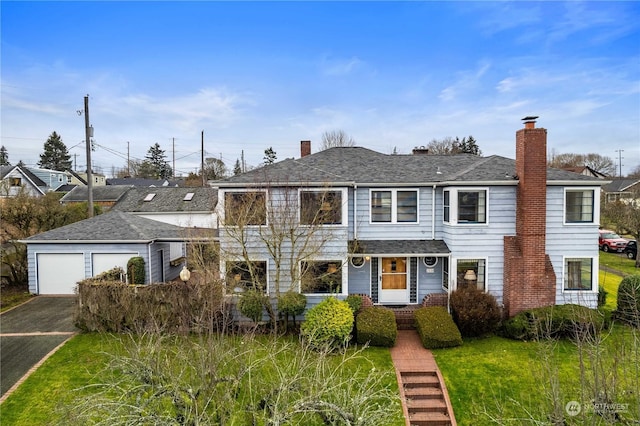 view of property featuring a garage and a front yard