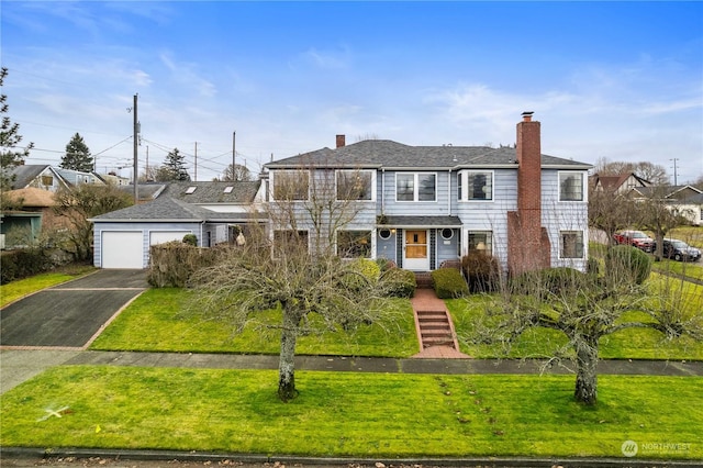 view of front of home with a garage and a front lawn