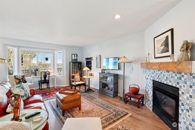 living room featuring hardwood / wood-style flooring and a tiled fireplace