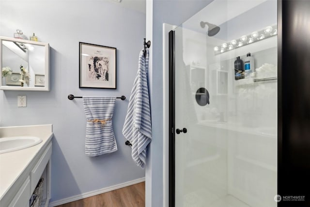 bathroom featuring vanity, a shower with door, and wood-type flooring