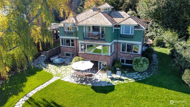 back of house with a balcony, a yard, and a patio area