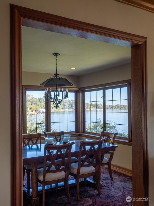 dining area with a water view and a chandelier