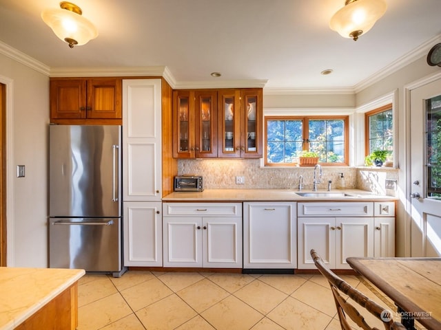 kitchen featuring white cabinetry, sink, ornamental molding, light tile patterned floors, and high end fridge