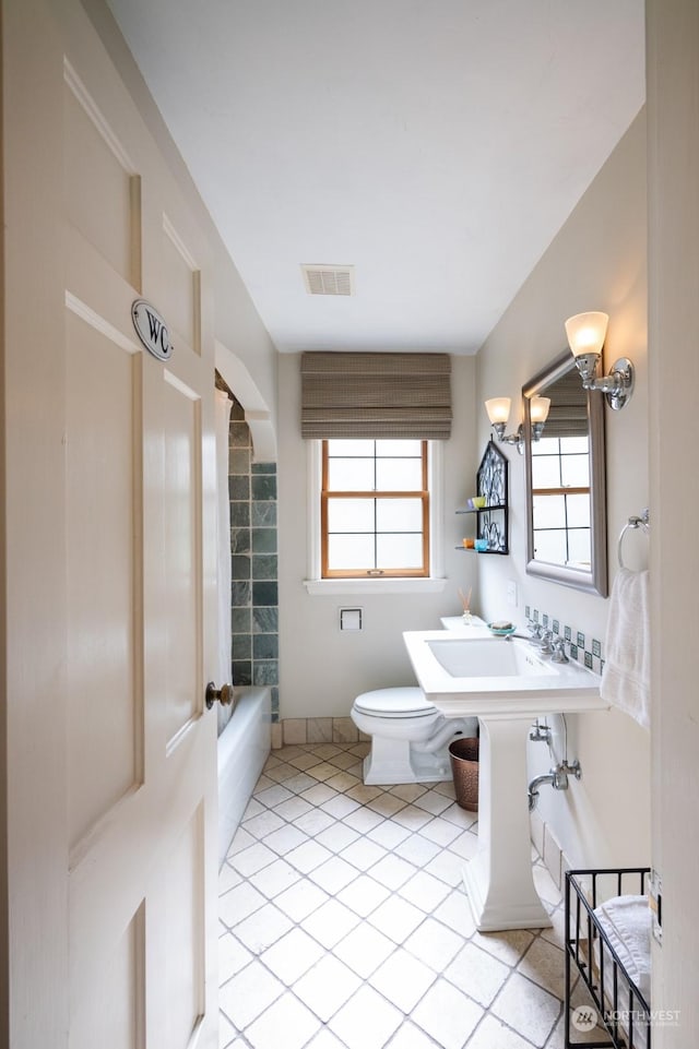 bathroom featuring tile patterned flooring, plenty of natural light, and toilet