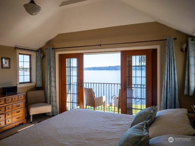 bedroom featuring a water view, vaulted ceiling, and multiple windows