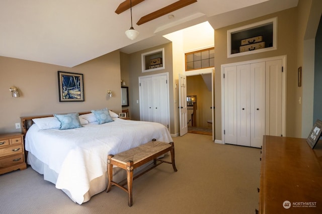 bedroom featuring high vaulted ceiling, two closets, light colored carpet, and ceiling fan