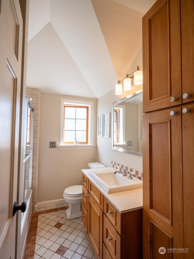 full bathroom featuring vaulted ceiling, tile patterned flooring, vanity, toilet, and bathing tub / shower combination