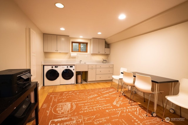 laundry area with washer and dryer, sink, and light wood-type flooring