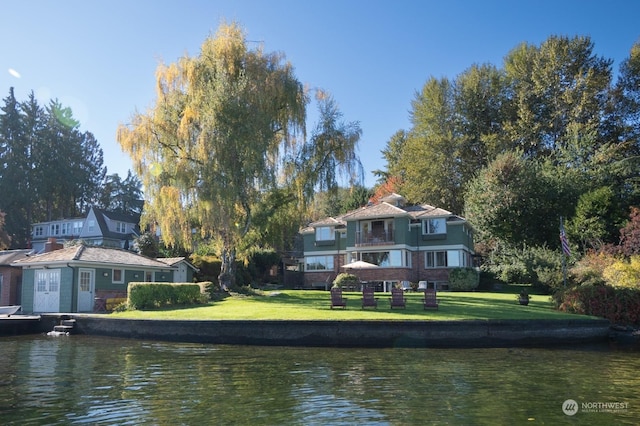 rear view of property with a water view and a lawn