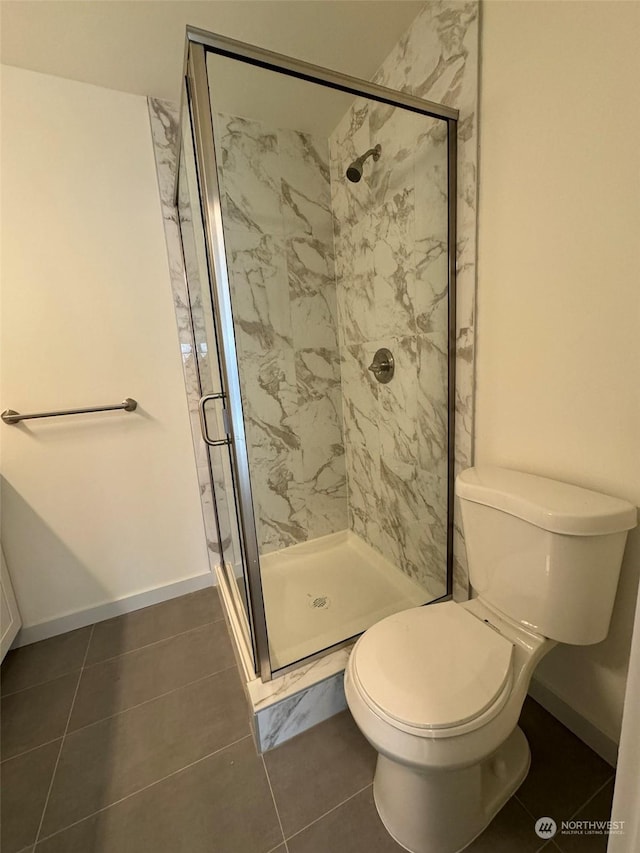 bathroom with tile patterned floors, toilet, and an enclosed shower