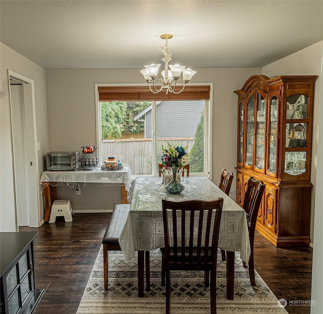 dining room with dark hardwood / wood-style floors and a notable chandelier