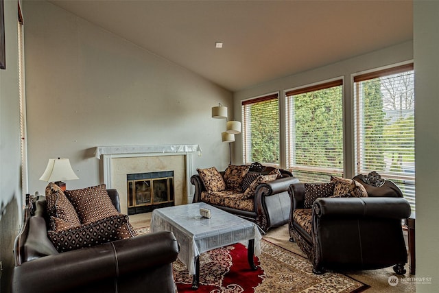 living room with a healthy amount of sunlight, lofted ceiling, and a premium fireplace