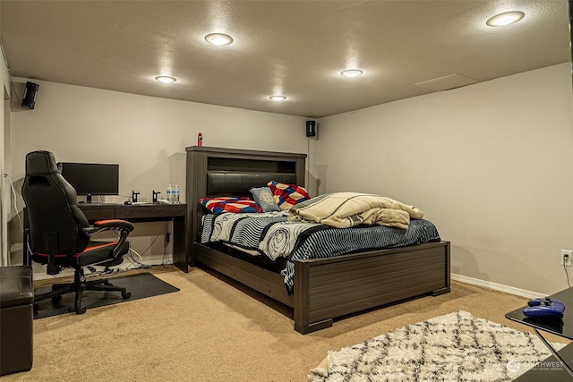 bedroom with light carpet and a textured ceiling