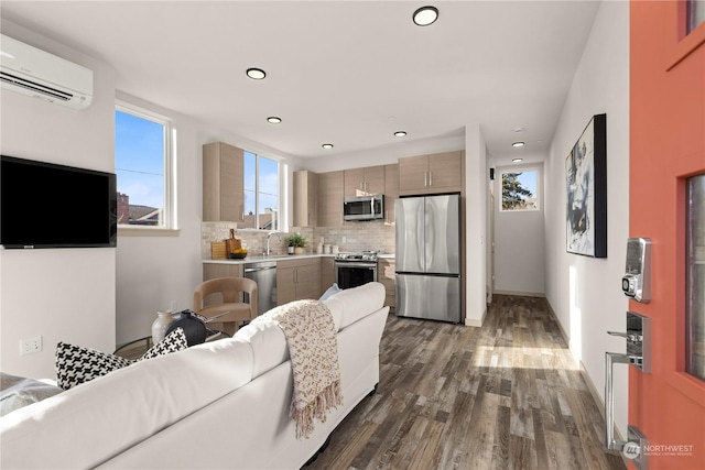 living area featuring baseboards, dark wood-type flooring, a wall unit AC, and recessed lighting