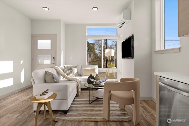 living room with wood finished floors, a healthy amount of sunlight, and a wall mounted AC