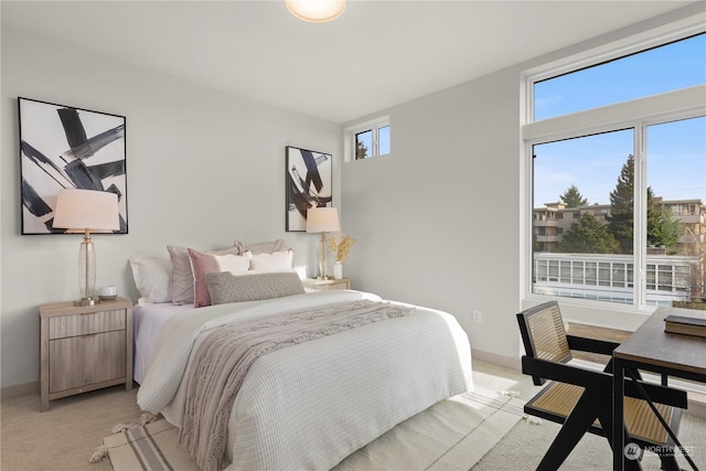 bedroom with light colored carpet and baseboards