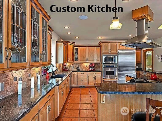 kitchen featuring sink, built in appliances, hanging light fixtures, island exhaust hood, and backsplash