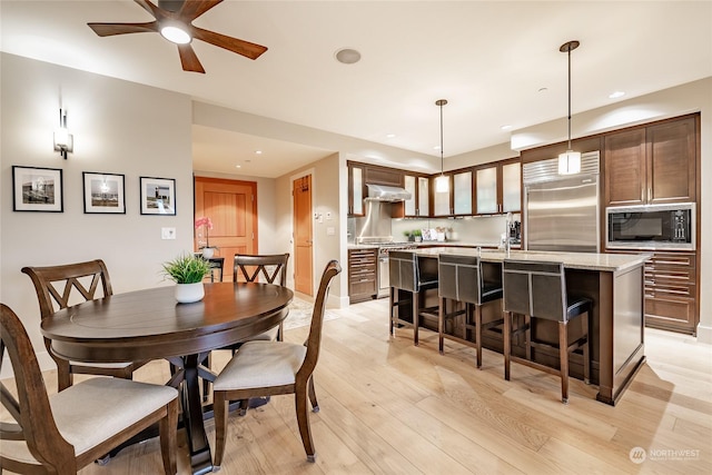 dining room with light hardwood / wood-style floors and ceiling fan