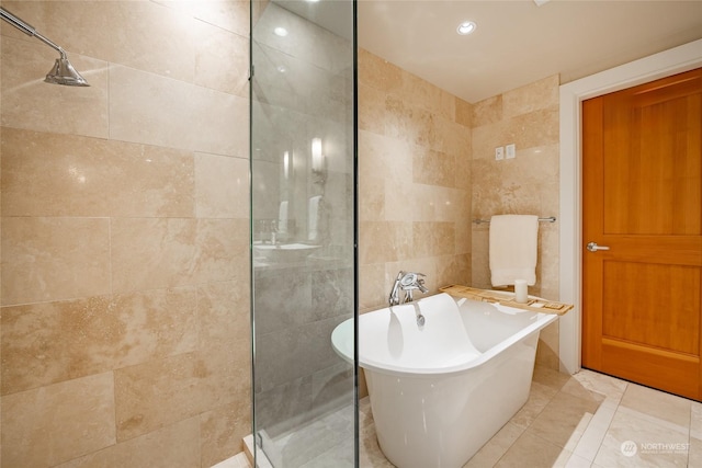 bathroom with tile patterned flooring, plus walk in shower, and tile walls