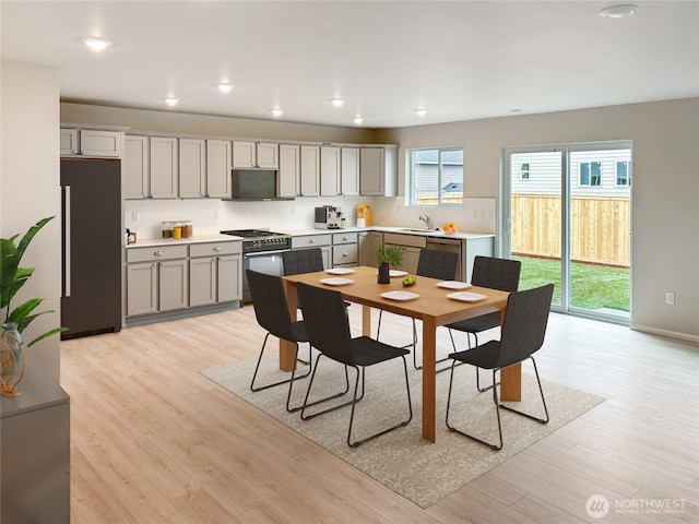 kitchen with light countertops, high quality appliances, light wood-style floors, and gray cabinetry