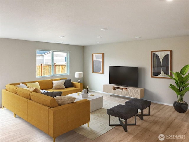 living area featuring baseboards and light wood finished floors