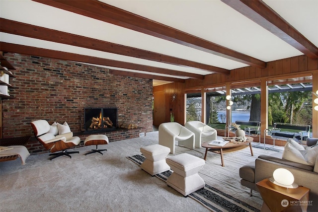 sunroom featuring beam ceiling and a brick fireplace