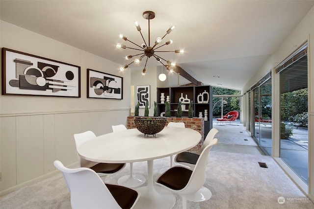 dining area with light colored carpet, a chandelier, and vaulted ceiling