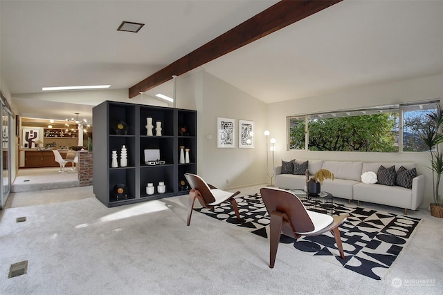 carpeted living room featuring lofted ceiling with beams and an inviting chandelier