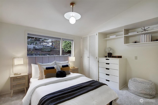 bedroom with lofted ceiling, light colored carpet, and a closet