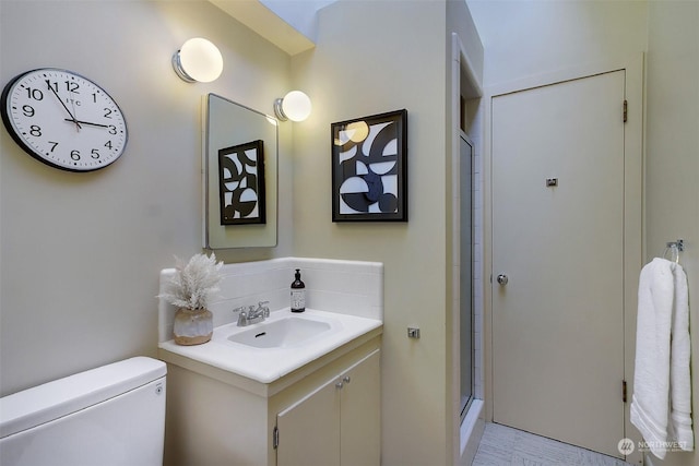 bathroom with vanity, toilet, and a shower with shower door