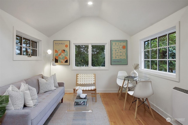 living room featuring hardwood / wood-style flooring, lofted ceiling, and radiator heating unit