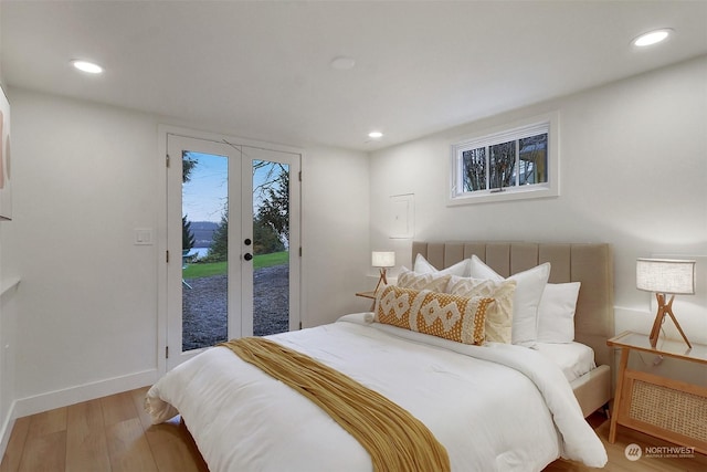 bedroom with hardwood / wood-style flooring, access to exterior, multiple windows, and french doors