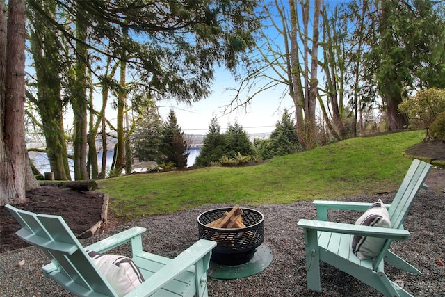 view of yard featuring a water view and an outdoor fire pit