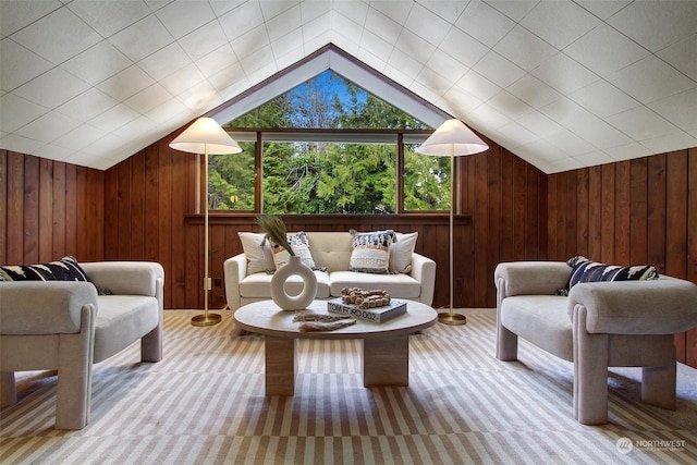 sitting room with lofted ceiling and wooden walls