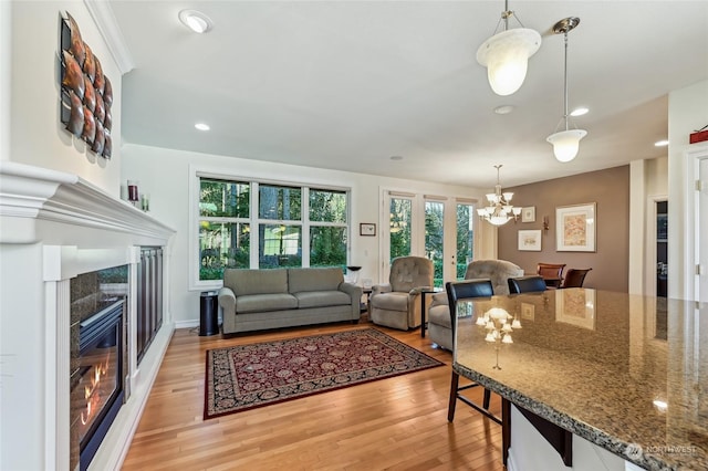 living room with a tiled fireplace, light hardwood / wood-style flooring, and a healthy amount of sunlight