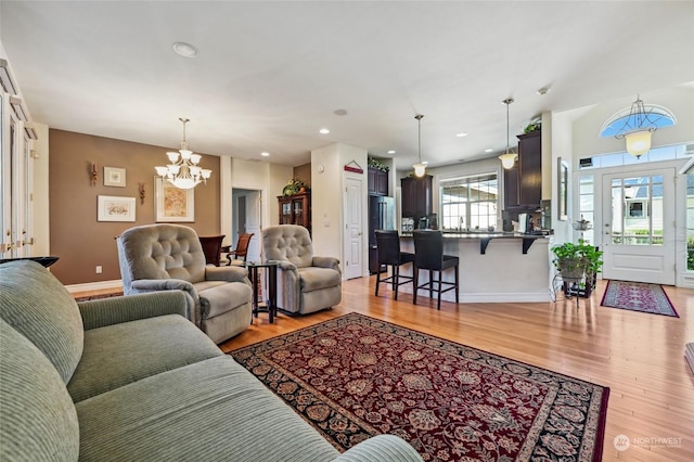 living room with an inviting chandelier and light wood-type flooring