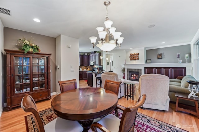 dining area with a notable chandelier and light wood-type flooring