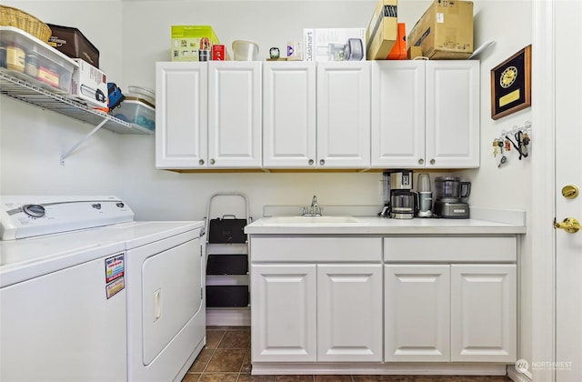 laundry area with cabinets, independent washer and dryer, dark tile patterned flooring, and sink