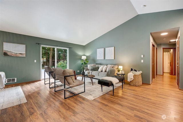 living room with high vaulted ceiling and light wood-type flooring