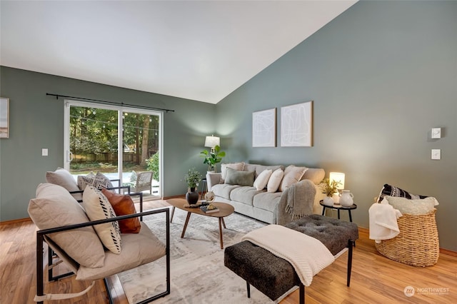 living room with high vaulted ceiling and light hardwood / wood-style floors