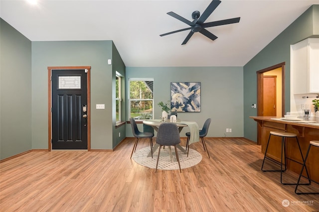 dining area featuring ceiling fan, lofted ceiling, and light hardwood / wood-style flooring