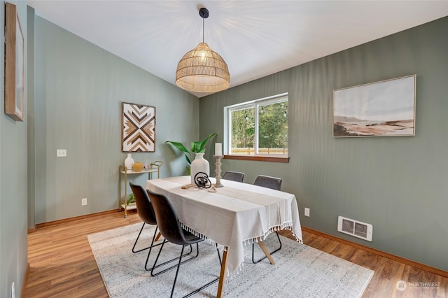 dining room with lofted ceiling and light hardwood / wood-style floors