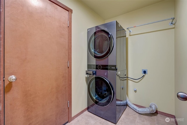 laundry area featuring light tile patterned flooring and stacked washing maching and dryer