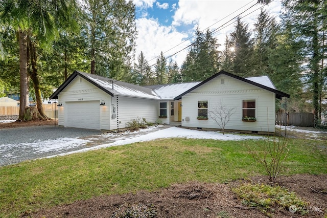 ranch-style house featuring a garage and a front lawn