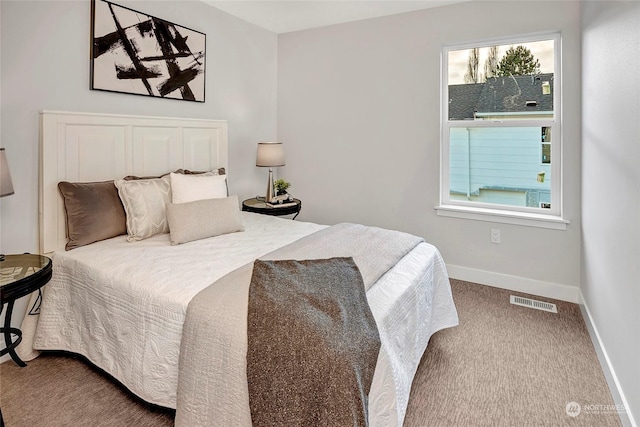 carpeted bedroom featuring visible vents, baseboards, and multiple windows