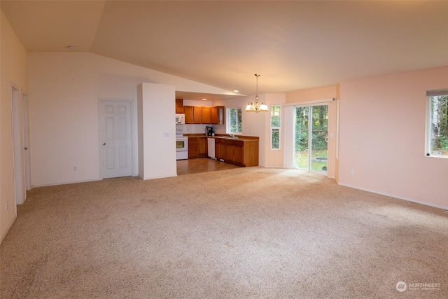 unfurnished living room with lofted ceiling, sink, light colored carpet, and a notable chandelier