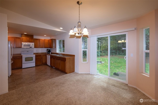 kitchen featuring lofted ceiling, sink, white appliances, dark colored carpet, and decorative light fixtures